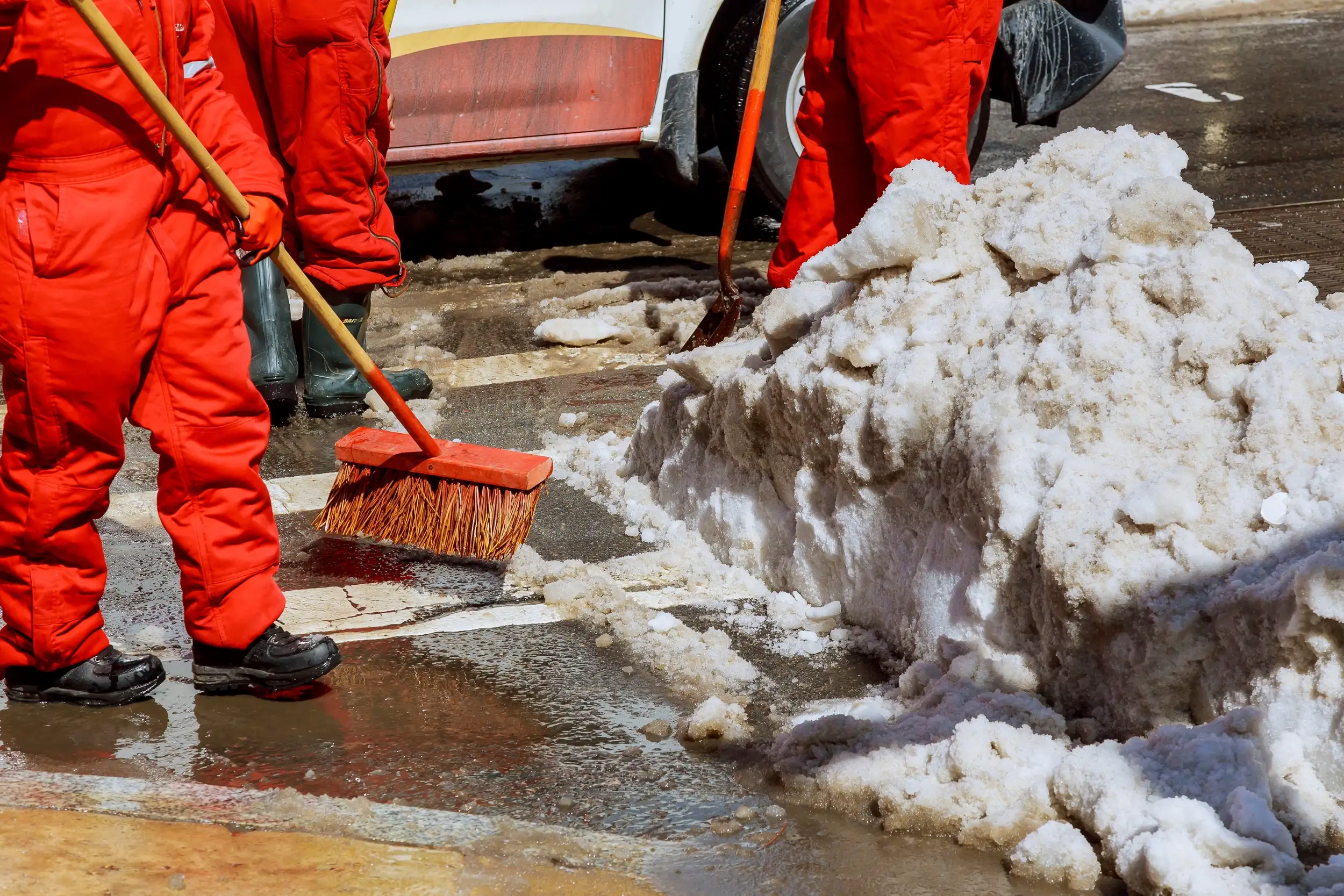 workers-sweep-snow-from-road-in-winter-cleaning